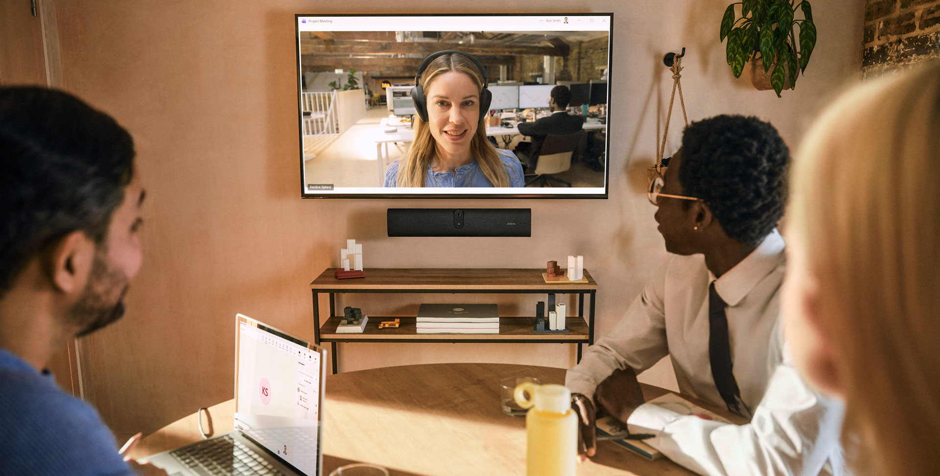 Small office huddle room with a wall-mounted Jabra PanaCast U30 video bar and display